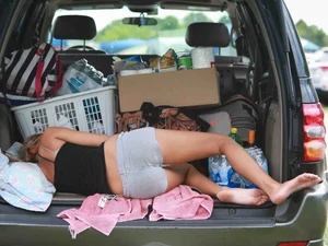 Skinny Girl in a Top and Shorts Asleep in a Car's Trunk