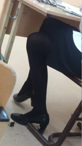 Teen in Black Pantyhose Sitting at the Desk Cross-Legged