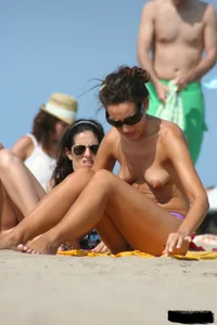 2 topless girls at the beach in thongs