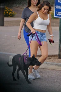 Sexy dog walker in shorts and tank top with friend in blue jeans