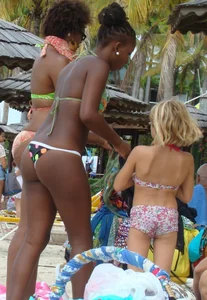 Sexy black babe in various bikinis on the beach while on vacation