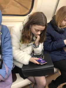 Very cute candid subway girl wearing black pantyhose sitting with crossed legs in the train