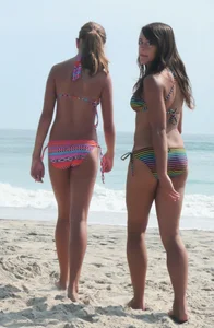 Two nice bikini girls walking on beach