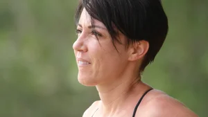 Mature short haired brunette surfer looking sexy on the beach