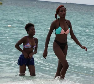 Candid black family, milf and teens on the beach in bikinis