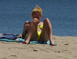 Sexy ass blonde milf on the beach in a thong with cameltoe and bending over