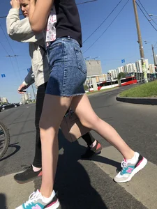 Cute Girl in a Short Denim Skirt Walking on a Street And Waiting on a Crosswalk Gallery
