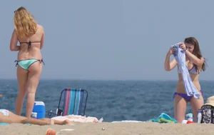 Cute girls in light blue and purple bikinis on the beach