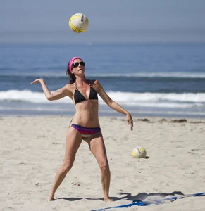 Hot girls playing beach volleyball in bikinis and shorts