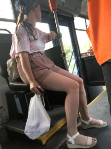 Young Girl in Sandals and Shorts in a Public Bus