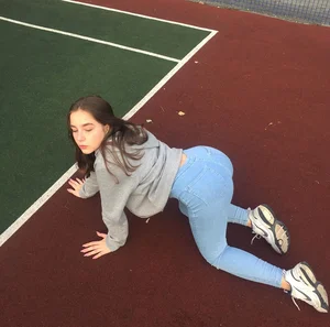 Girl in Light Blue Jeans Doggy Style on the Ground at the Stadium