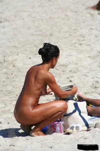 Smoking milf at a nude beach with a hairy pussy