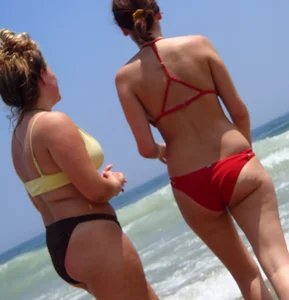 Thick girl and her skinny friend in bikinis at the beach