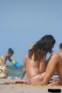 2 topless girls at the beach in thongs