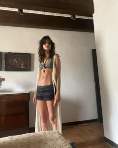Extremely cute skinny candid girl wearing a bra and shorts at home