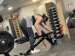Sexy Lady in Grey Leggings Lifting a Dumbbell Bent Over Creepshots