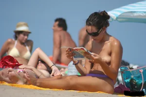 2 topless girls at the beach in thongs