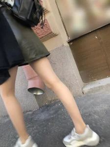 Nice slim legs of a candid girl wearing a leather skirt