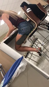 Cute teen wearing denim shorts sitting on a bar stool