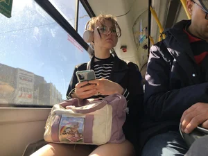 A Very Cute And Skinny Candid Teen Girl Wearing Glasses, A Skirt And Knee Socks Sitting in a Public Bus, Closeups of Her Legs