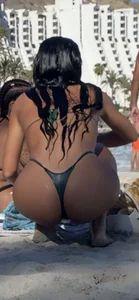 Amazing ass on the beach wearing a Green micro bikini