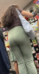 Hot brunette milf in green yoga flare at GameStop