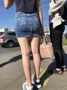 Cute Girl in a Short Denim Skirt Walking on a Street And Waiting on a Crosswalk Gallery