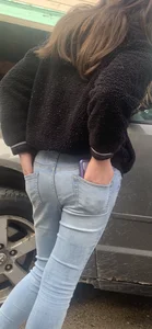 Teen wearing jeans with her hands in back pockets