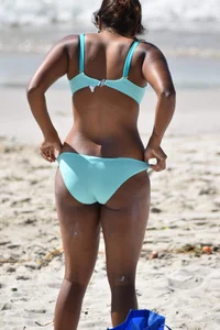 Tanned brunette girl on the beach in a bikini