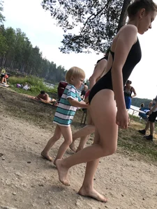 Cute Barefoot Girl in a Black Body Swimsuit Walking on a Road