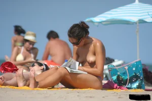 2 topless girls at the beach in thongs