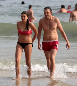Skinny small boobed girl in a bikini on the beach with her friend