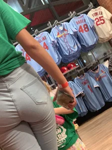 Bunch of girls in various outfits at a Cardinals baseball game