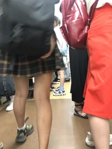 Skinny Teen in a Chequered Skirt With a Backpack in a Subway