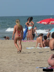 Sexy mom and daughter in red thongs at the beach