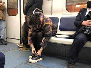 Cute Teen in Black Pantyhose And Sneakers Tying Her Shoelaces in a Subway Train