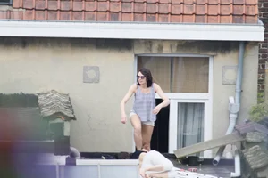 Neighbor on rooftop tanning in bikinis