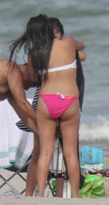 Brunette bikini girl on the beach and surfing in her bikini