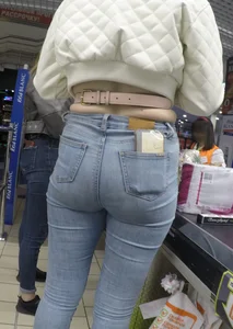 Two hot milfs in tight blue jeans standing at the cash register at the supermarket, awesome big butts