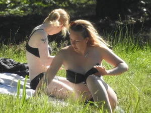 Two sexy friends in black bikinis laying out