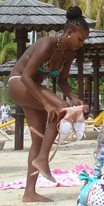 Sexy black babe in various bikinis on the beach while on vacation
