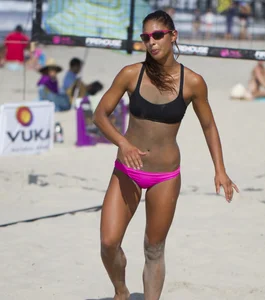 Hot girls playing beach volleyball in bikinis and shorts
