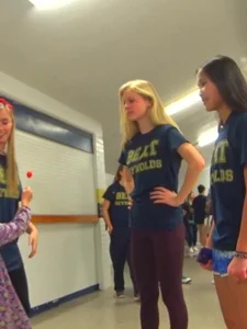Skinny college teen in leggings bending over a drinking fountain