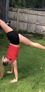 Fit gymnast girl in spandex shorts training in the backyard