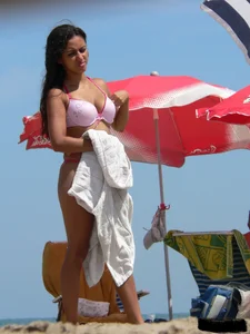 Hot brunette ethnic girl on the beach in a pink thong bikini