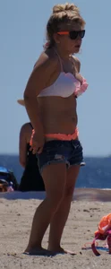 Thick blonde girl in an orange bikini on the beach