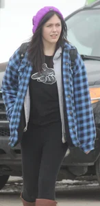 A cute brunette in leggings boots and hat