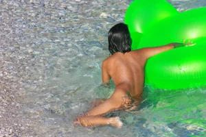 FKK Nudists playing in the water with floater