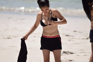 Beach girl can't keep her tits in her bikini