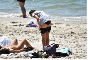 Sexy girl undressing to her bikini on the beach with an amazing body
